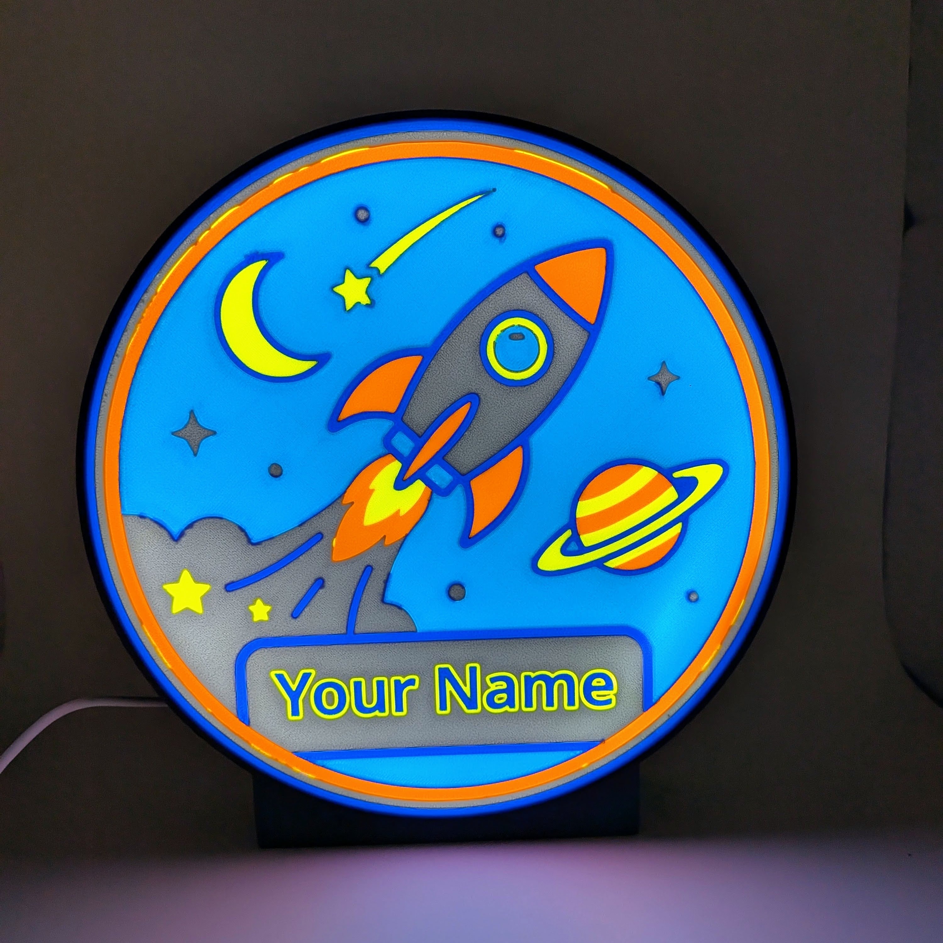 Lampada LED con nome personalizzato e grafica spazio: razzo, luna e pianeta, luce accesa