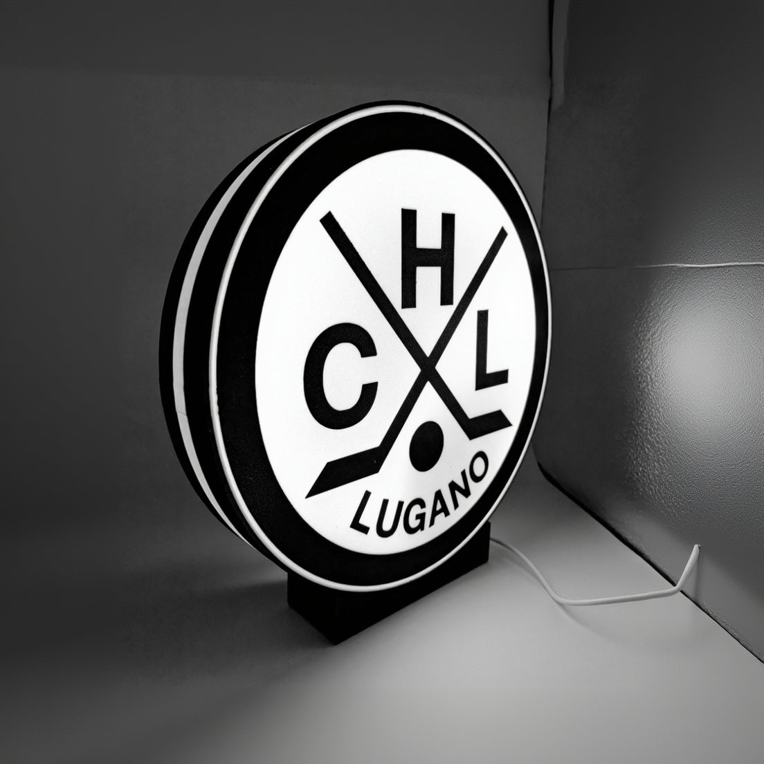 Round LED lightbox with Lugano hockey logo, black and white face, glowing ring border