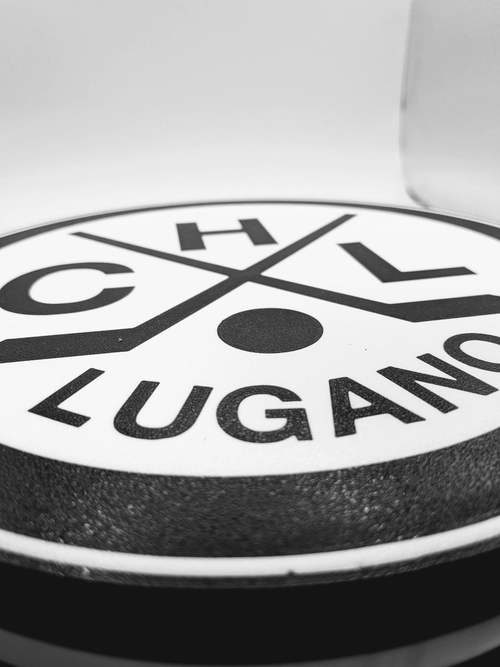 Lampada LED HC Lugano close-up: scritta LUGANO su fondo bianco e bordi neri
