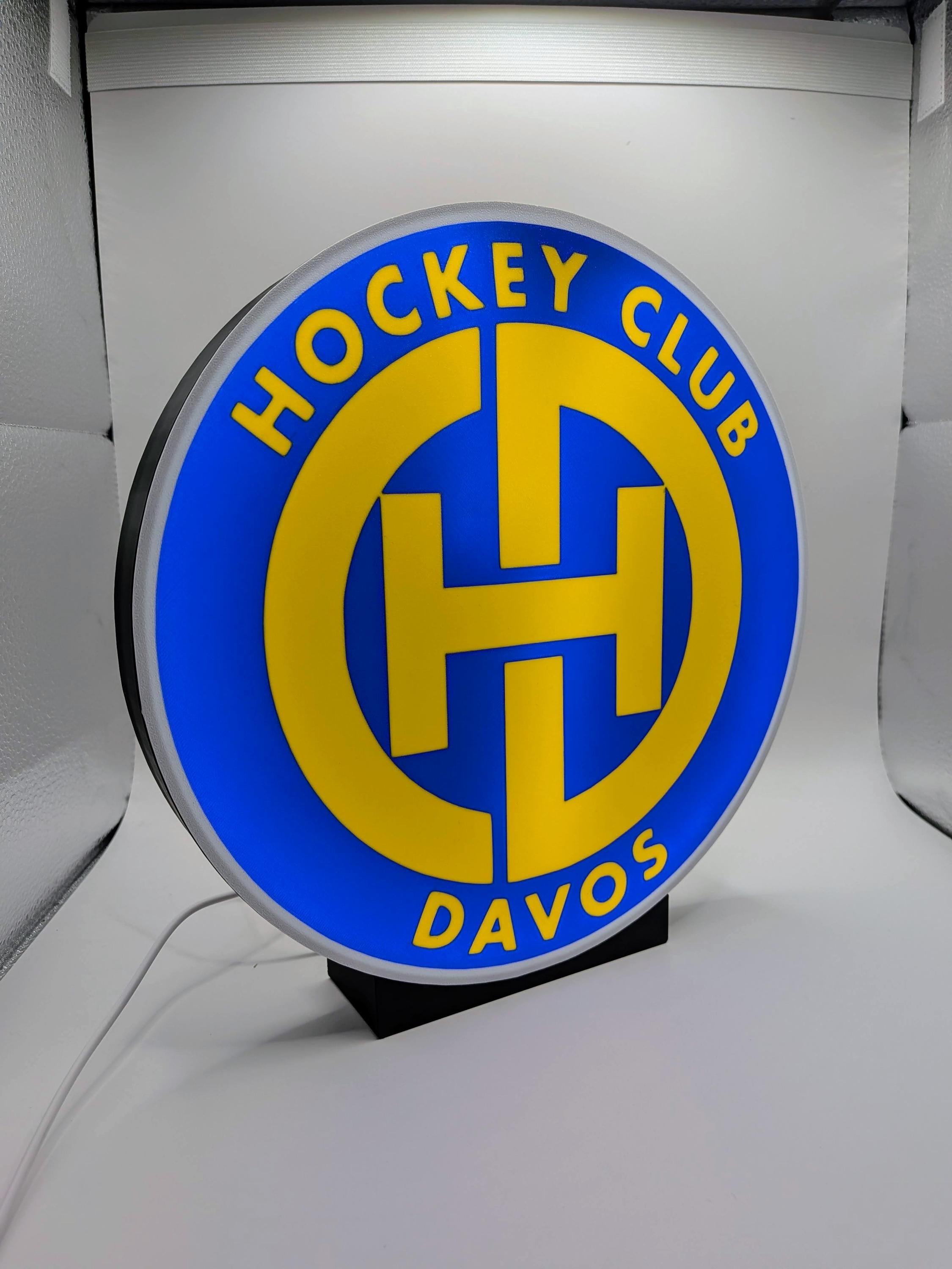 Lampada LED lightbox tonda con logo Hockey Club Davos, dettagli del simbolo giallo-blu.