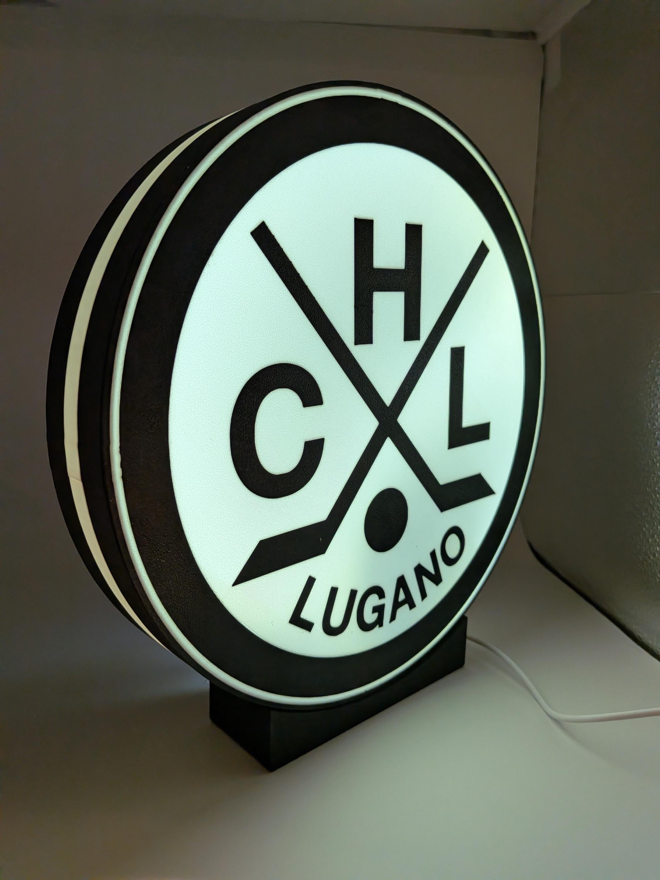 Lampada LED circolare HC Lugano accesa con bordo luminoso verde e base nera