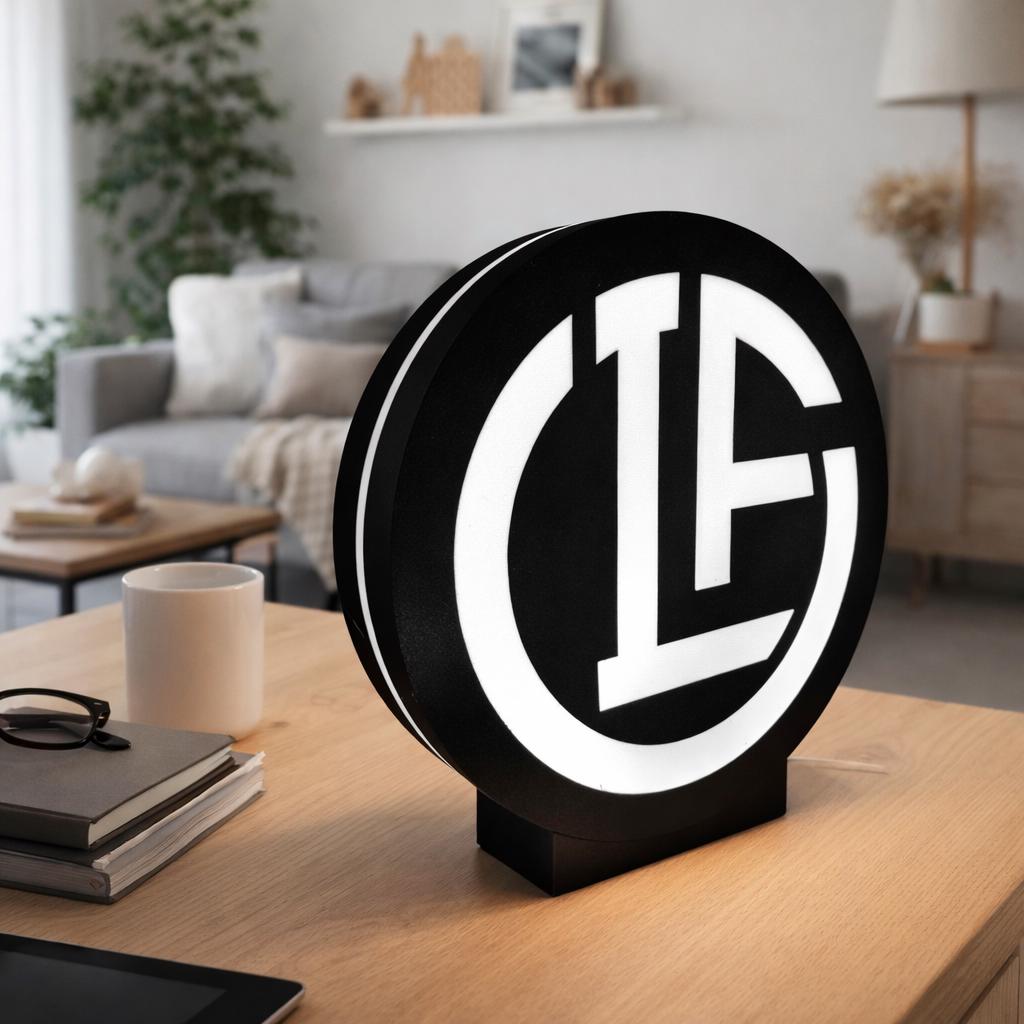 Black round LED lightbox on table with white circular emblem logo