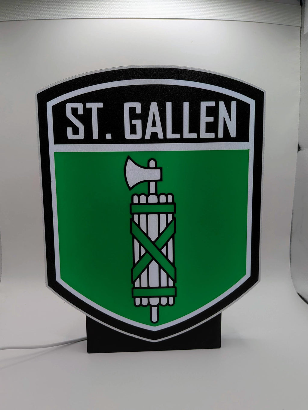 Lampada LED lightbox St. Gallen con stemma su sfondo verde, corpo nero