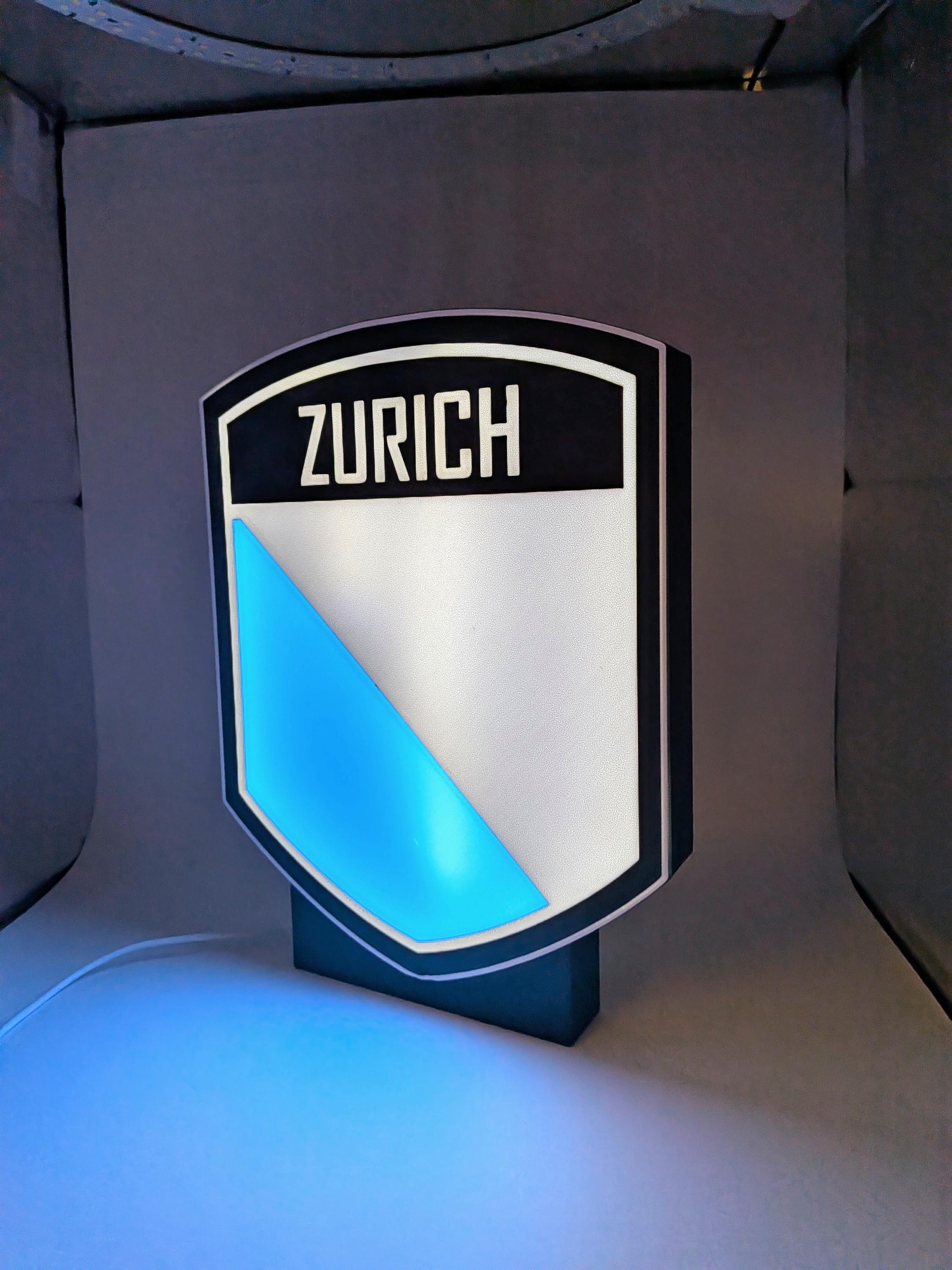 Lampada LED lightbox scudo ZURICH con triangolo blu e luce blu verso il basso